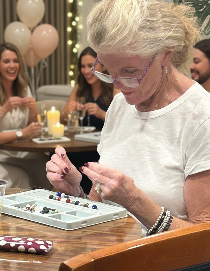 Woman carefully stringing gemstone beads