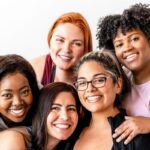 Group of diverse women smiling together, representing community, connection, and empowerment.