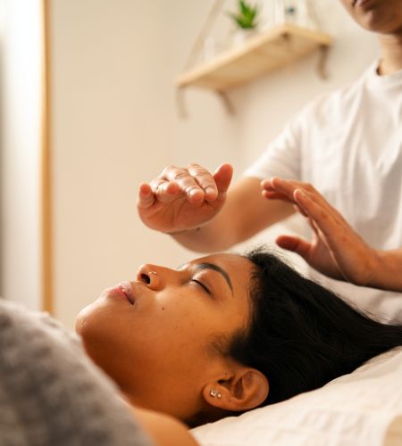 Reiki energy healing session at My Healing Suite, with a practitioner channeling energy above a relaxed woman to promote balance, stress relief, and natural healing.