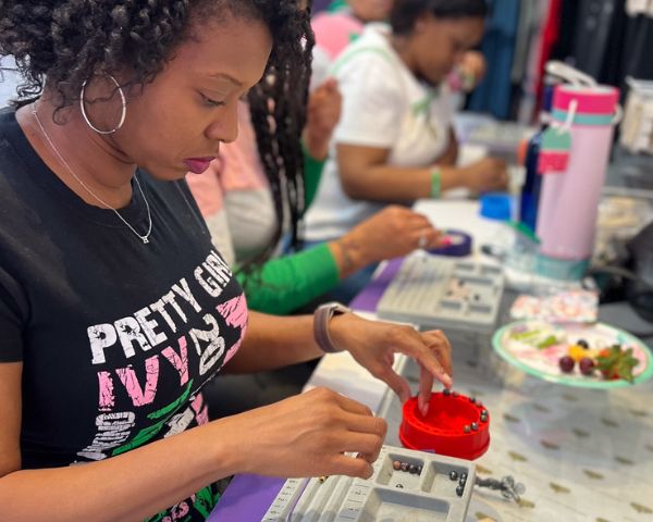Wellness Experiences Woman crafting a healing crystal bracelet during a Sip & String intention-setting workshop at My Healing Suite in National Harbor.